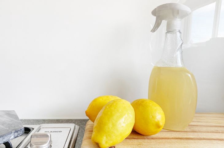 Kolm sidrunit ja sidruni mahla täis puhastusvahendi pudel